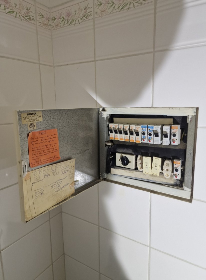 Oud metalen Pantex-kastje met smeltzekeringen in een betegelde badkamer in Zaventem, vóór